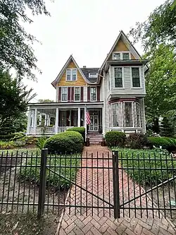 two and a half-story house with large porch and irregular roof line
