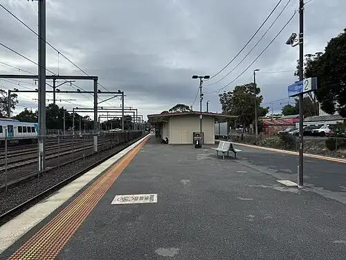 Northbound view from Platform 2 at Eltham station, the station building can be seen to the right and a stabled X'Trapolis to the left