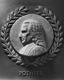 A grey marble sideview of Robert Joseph Pothier. He is looking to the left, and has judiciary garments on. Surrounding the circular frame is a laurel wreath. Under the engraving is the text "POTHIER".
