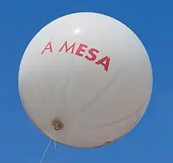 A white balloon with red text: "A Mesa"