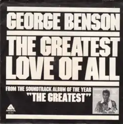 Text in uppercase and large size; black background. Artist name ("George Benson"), song title ("The Greatest Love of All"), and info about parent soundtrack album ("From the soundtrack album of the year, 'The Greatest' ") divided by lines. The song title is divided into two lines, breaking "Greatest" and "Love" apart. The soundtrack info contains the Arista Records logo on the leftmost and the cover art of the parent album on the right.