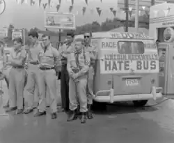 Black and white photo of ANP members wearing swastika armbands in front of a band labeled "Lincoln Rockwell's Hate Bus" and "We Do Hate Race Mixing"