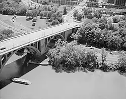 Aerial view of Key Bridge and George Washington Memorial Parkway, with pier of Aqueduct Bridge visible in the foreground and remnant of Aqueduct Bridge abutment visible on the Virginia shoreline (c. 1990)