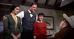 Black and white film still showing Katy Jurado and Pina Pellicer being embraced by Karl Malden while looking at Marlon Brando