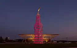 Bottle sculpture lit up at night