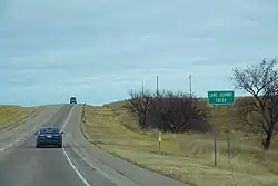 An open road with a sign labeled "Lame Johnny Creek"