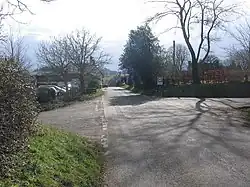 Street scene with houses dotted amongst the trees.