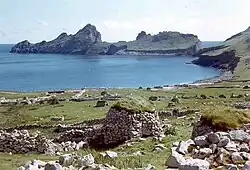 Island coast with cliffs and ruins of stone buildings