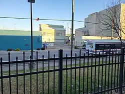back of a bus behind a wrought-iron fence